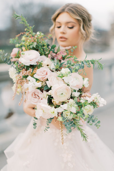 bride holding bouquet with white and pink florals during outdoor bridal shoot