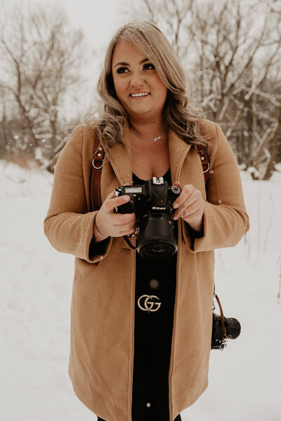Photographer in snowy weather looking at her camera