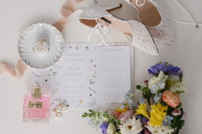wedding invitation flay lay that includes jewelry and shoes