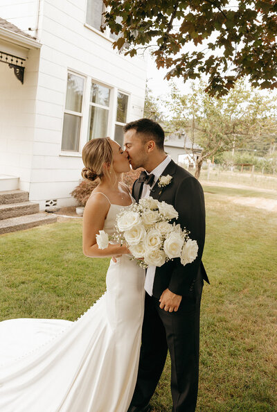 Groom holding his bride, bride wearing veil holding bouquet