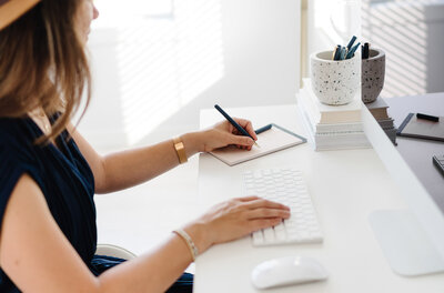 Women sitting in her office writing on a note pad