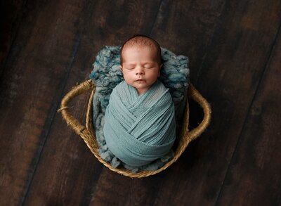 A smiling newborn on grey.