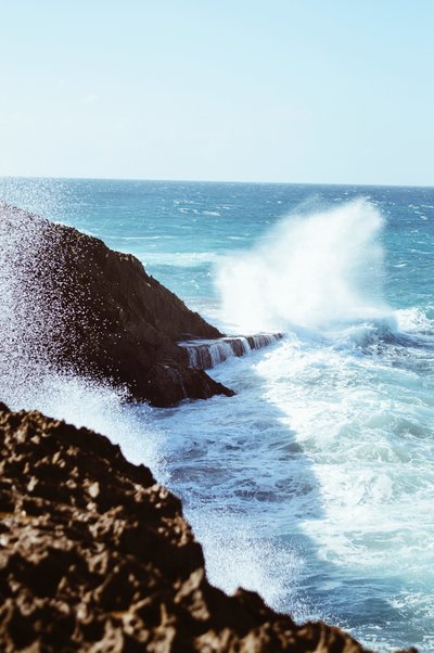 ocean waves splash against rocks