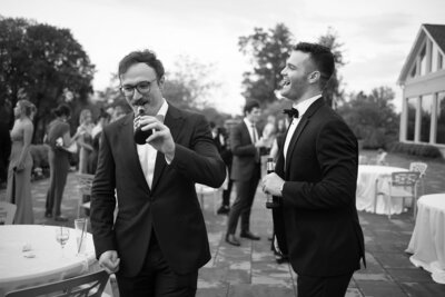 A candid photo of wedding guests sharing a laugh at cocktail hour