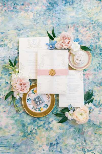 Dolce and Gabbana perfume box surrounded by white hydrangea flowers and wedding rings