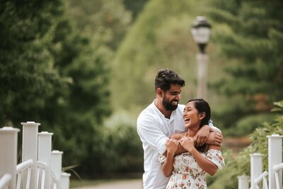 New Jersey Engagement session south asian couple embracing each other​ with green scenery behind.