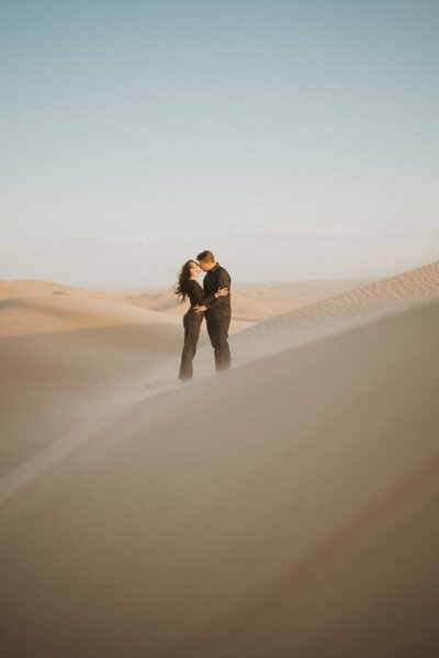 couple hugging in sand dunes