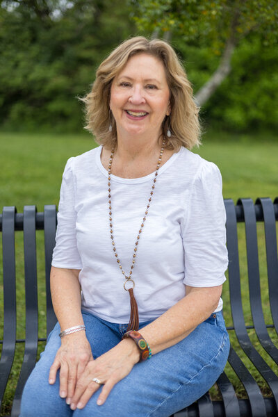 Woman on bench in white shirt