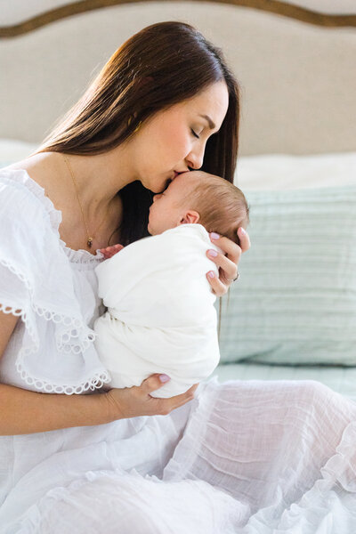 young mother kissing newborn during atlanta newborn phtography session