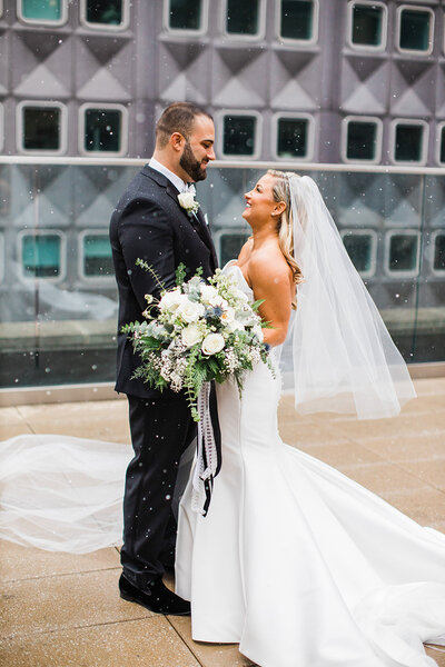 Bride and Groom  Smiling at Eachother Standing on Hotel Monaco Rooftop