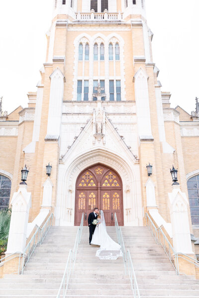 Bride and groom in front of Our Lady of Lake University Chapel