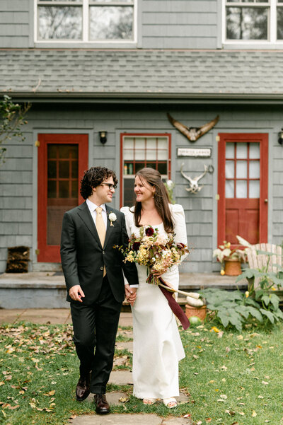 Bride and groom walking towards camera while smiling at each other