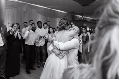 extremely happy couple hug one another in front of all family and guests at their wedding reception. Cleveland, Ohio. Photographed by Aaron Aldhizer