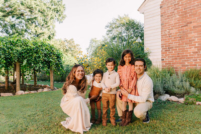 a family of five sitting on a park at coker arboretum and having their photo taken by rosa ashdown