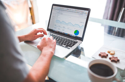 A professional from the best Google Ads agency working on a laptop with a coffee next to him, illustrating productivity and expertise in managing Google Ads campaigns.