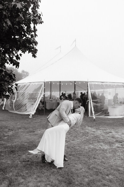 Groom dipping bride backwards while kissing her