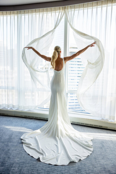 Beautiful bride showing her long sexy legs during wedding photoshoot in downtown Chicago river walk.