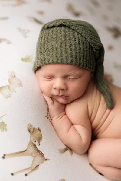 Beautiful baby boy wrapped in a hand knitted  green wrap with matching bonnet.