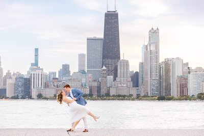 Engagement photography in Chicago IL at  Lake Michigan; man and woman staring at each other in front of the Chicago skyline