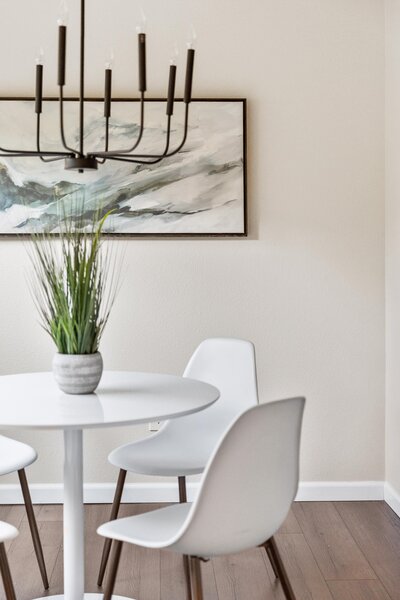 Vacant condo dining area staged by Modern Mollusk in Snohomish County featuring modern white furniture and minimalist decor.
