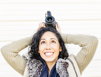 Asian photographer posing with camera on her head