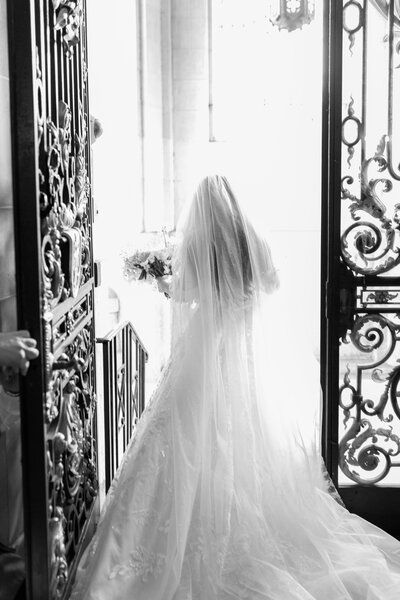 A bride leaving the iron gates of the ceremony just after getting married