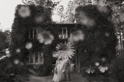 Bride and groom standing in front of an ivy-covered building with floral double exposure overlay, captured by a Washington wedding photographer.