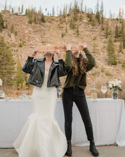 Bride and photographer take a shotski at her wedding in the mountains of Colorado