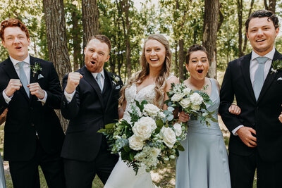 bride and groom smiling with bridal party