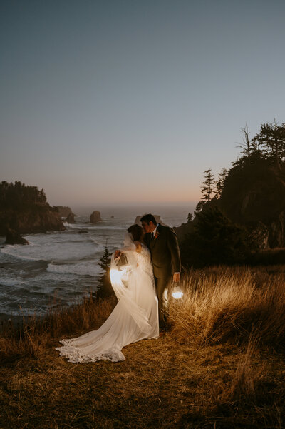 Couple holding lanterns during elopement at Secret Beach, OR