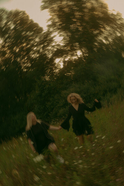 Man and woman romantically spin around, laughing in the middle of a  flowery field