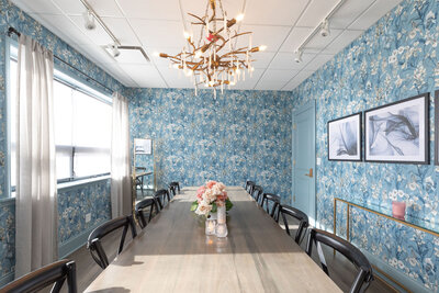 perfectly themed suite or conference room space for clients to enjoy, natural light accentuating detailed wallpaper and chandelier accent