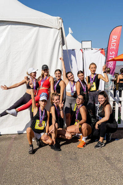 HER Sports Club members posing together after a race event during the annual membership season.