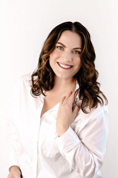 A woman in a white shirt smiling at the camera.