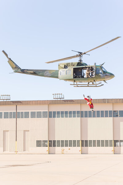 Santa riding the hoist on an Air Force helicopter