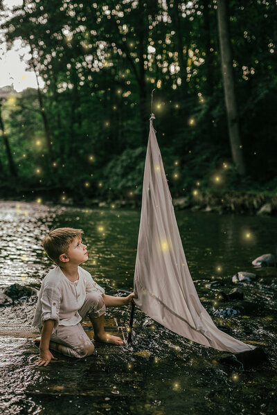 Boy on raft in creek with fireflies Jessica Carr Photography