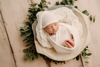 newborn baby wrapped in white for his newborn photos in cleveland ohio