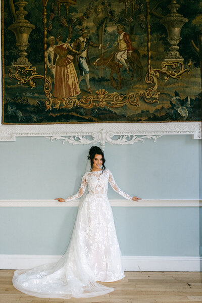 A wedding photo of a bride in a beautiful white wedding dress posing in the halls of Luttrellstown Castle