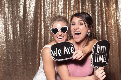 Girls posing with props in front of rose gold sequin backdrop