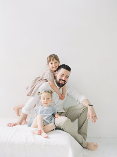 Seattle family photos, daughter and father candid on film in all white studio.