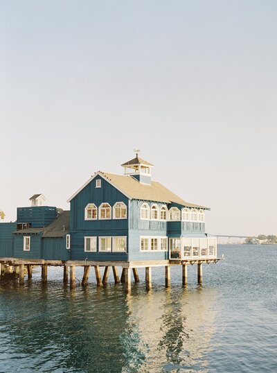 blue house on stilts over water in California print photo