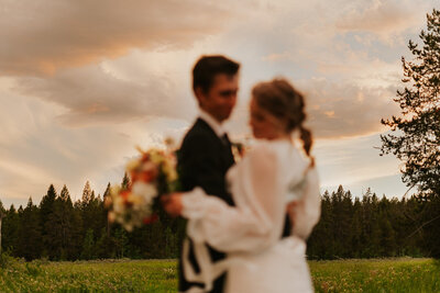 Rexburg Idaho bridals photographer. An image with the bride and groom blurred in the foreground, with the trees in the background clear.