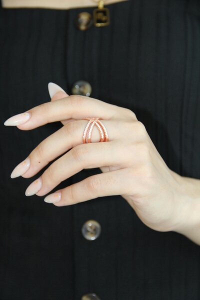 Elegant hand with long almond-shaped enhancements and soft pink polish, representing the detailed artistry of nail enhancement services.