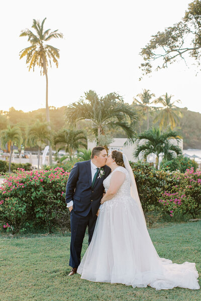 Bride and groom kiss in tropical resort in St. Lucia