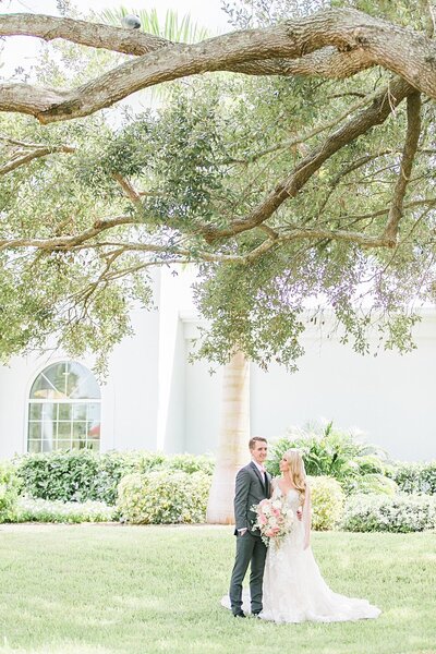bride and groom posing underneath oak tree