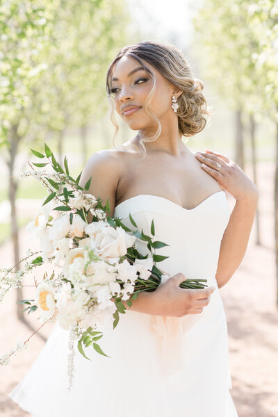 bride standing looking over left shoulder while holding bouquet