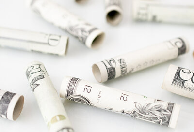 Image of rolled up money, focusing on how to save money right now