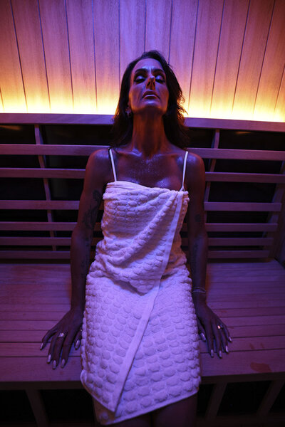Woman in white towel in infrared sauna