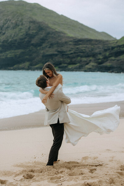 bride and groom embracing on beach