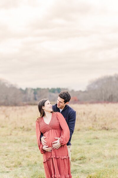 girl sits on dad's shoulders and dad smiles at mom during family photo session with Sara Sniderman Photography in Metro West Boston Massachusetts